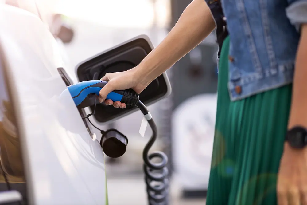 A driver charges her electric vehicle.