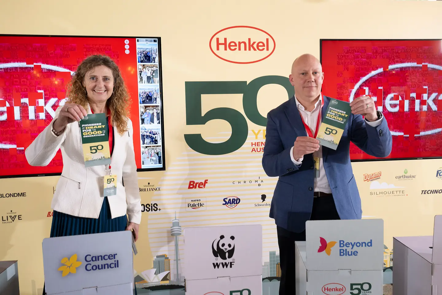 Two employees gather around boxes featuring shortlisted charitable organizations.