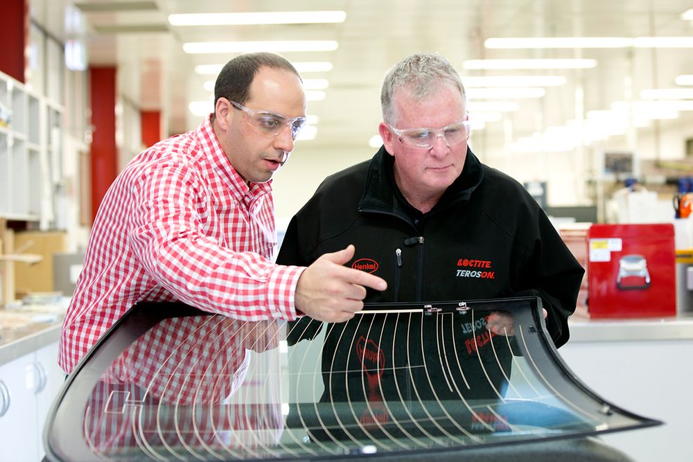 Micheal Hajj (left), Technical Manager for Adhesive Technologies, Henkel ANZ, and Steven Dew (right), Assistant General Manager for Sales, Henkel Australia, inspecting a windscreen at Kilsyth.