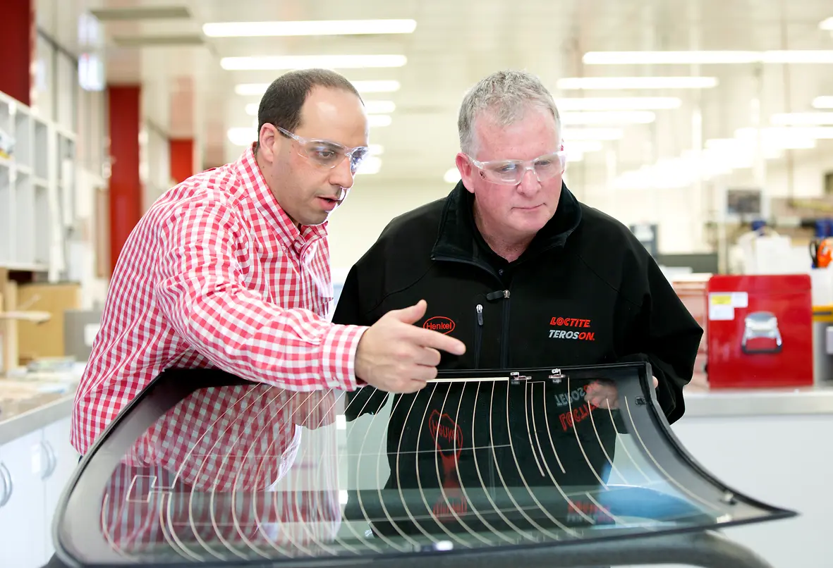 Micheal Hajj (left), Technical Manager for Adhesive Technologies, Henkel ANZ, and Steven Dew (right), Assistant General Manager for Sales, Henkel Australia, inspecting a windscreen at Kilsyth.