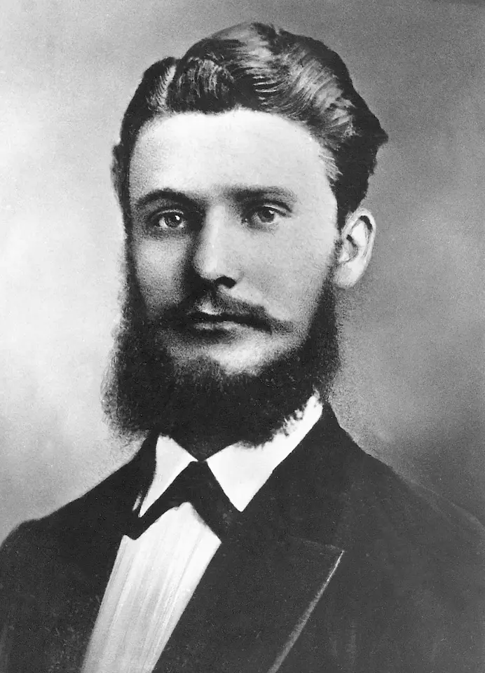 Historic black-and-white portrait of Frtiz Henkel in formal attire with a full beard and neatly combed hair.